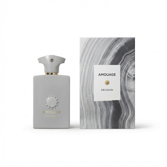 Amouage Decision fragrance bottle in a matte light gray finish with a gold-toned collar and matching cap, standing next to its packaging box which features a gray and white marbled pattern and a white label.